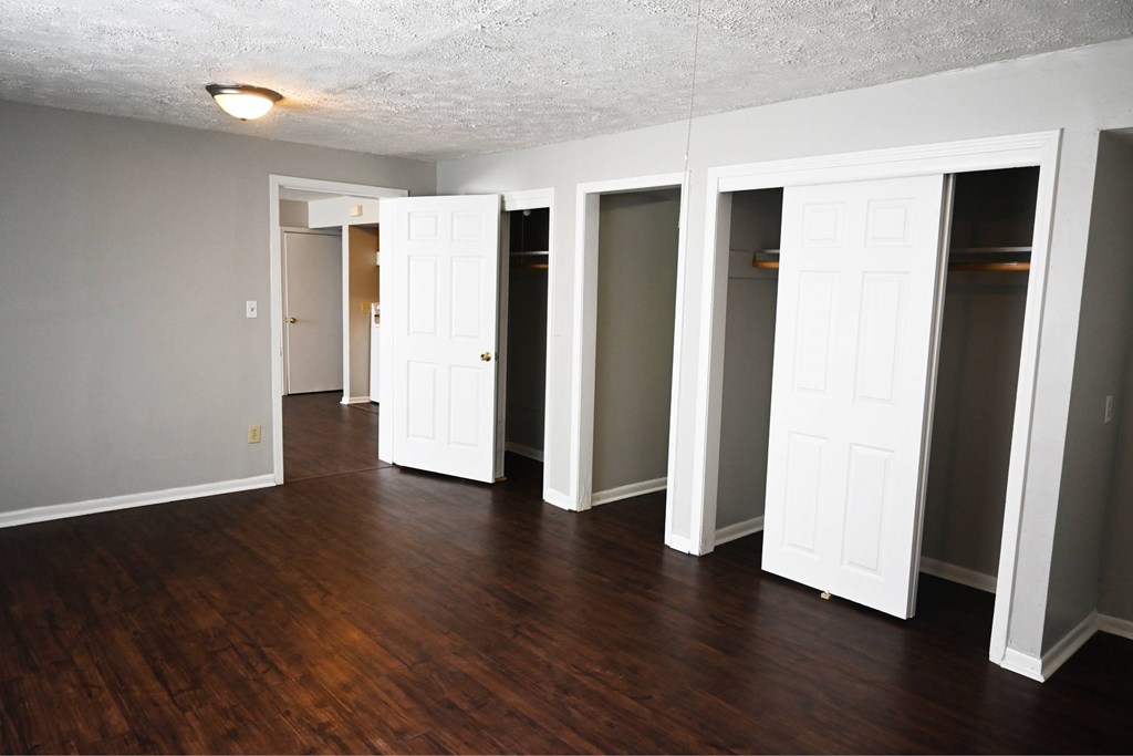 A room with white doors and wooden floors.
