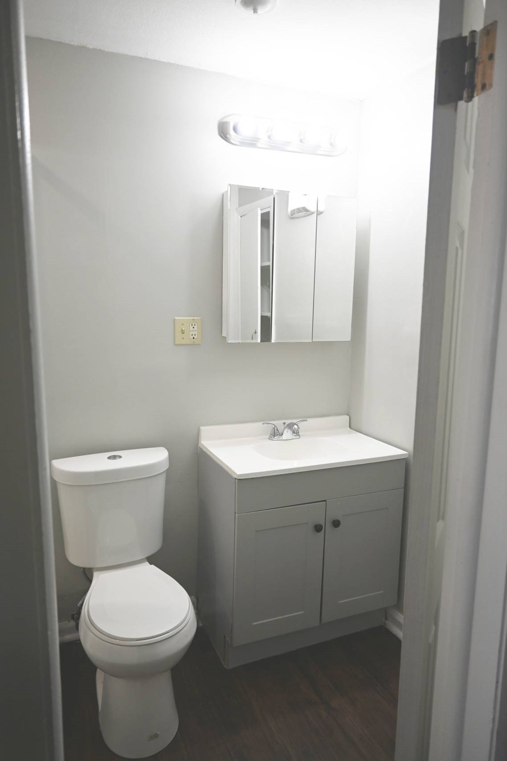 A white toilet and sink in a small bathroom.