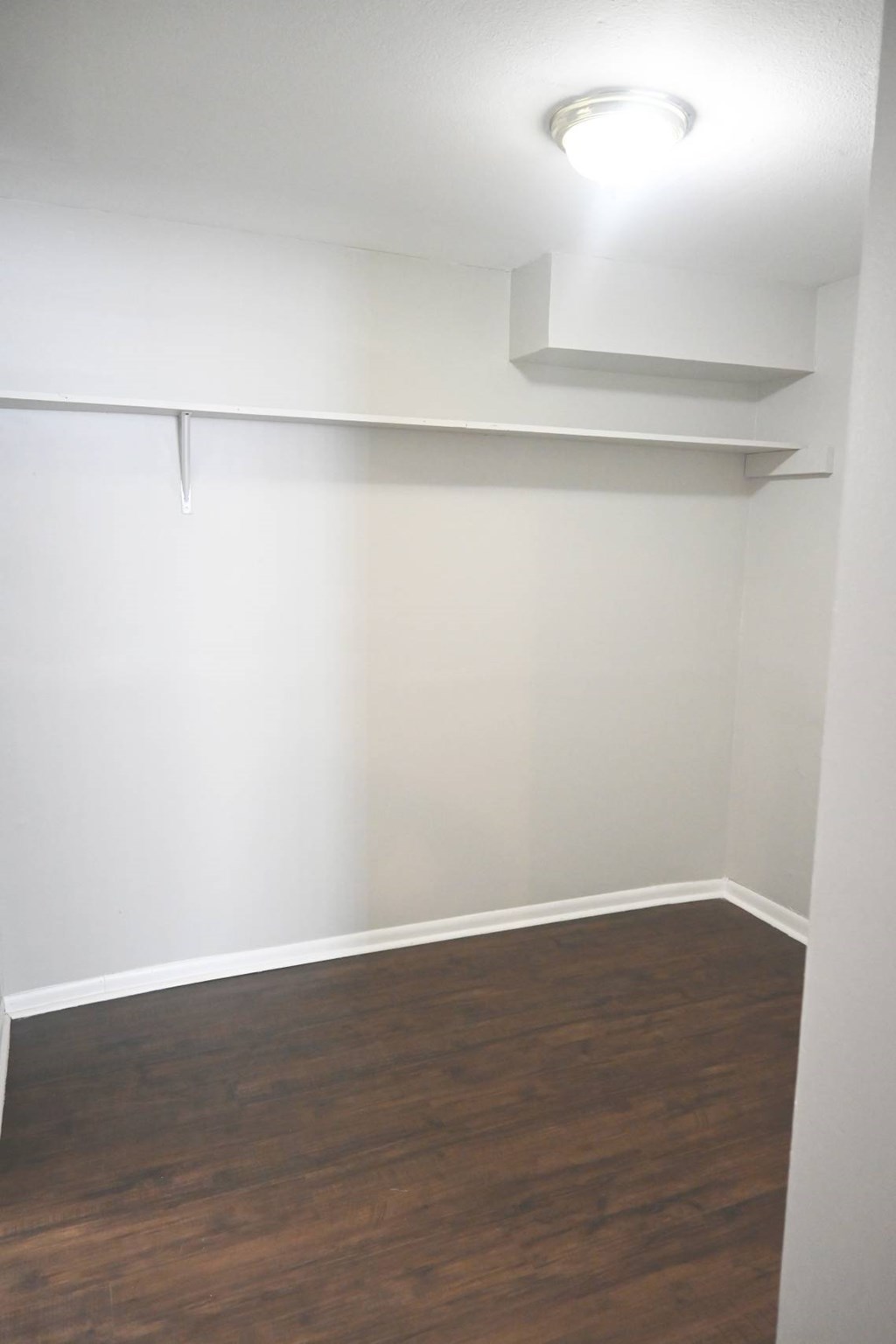 A room with a light on the ceiling and a wooden floor.