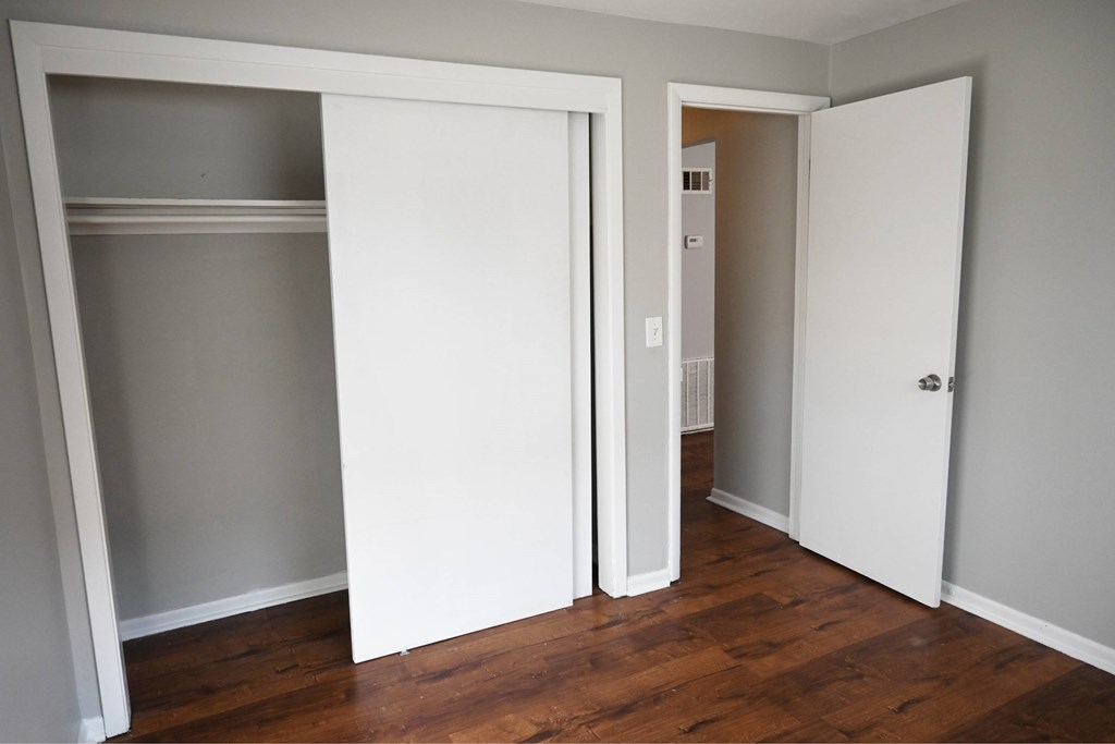 A room with a white door and a white shelf.