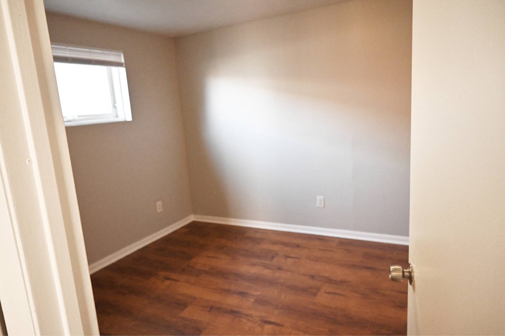 A room with wooden floors and a window.