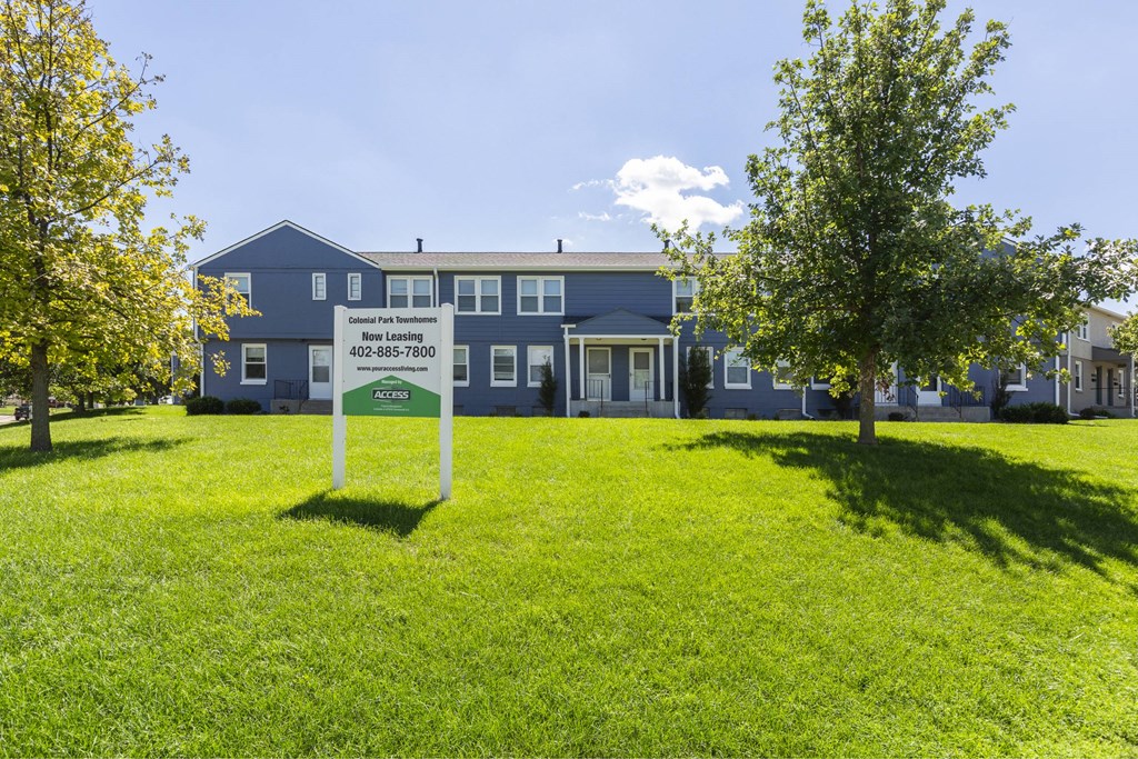A blue building with a sign in front of it.