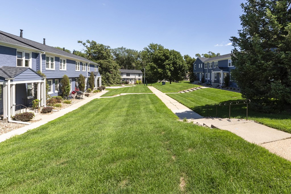 A grassy lawn leads to a row of houses.