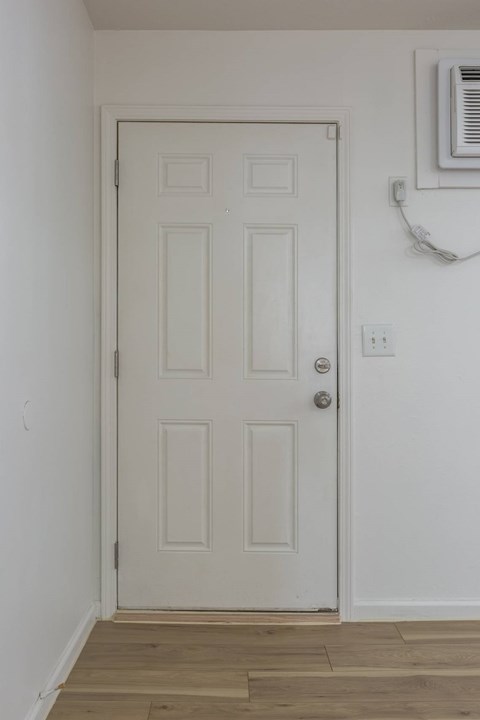 A white door with a silver handle and a window above it.