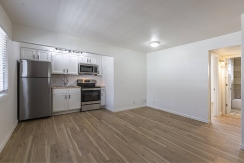 A kitchen with a refrigerator, oven, microwave, and cabinets.