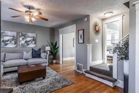 A living room with a grey couch and a wooden coffee table.