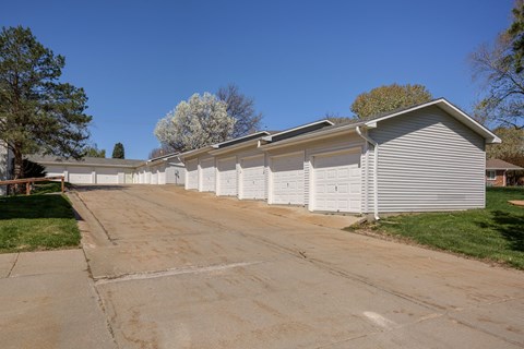 A long white garage with a driveway in front of it.
