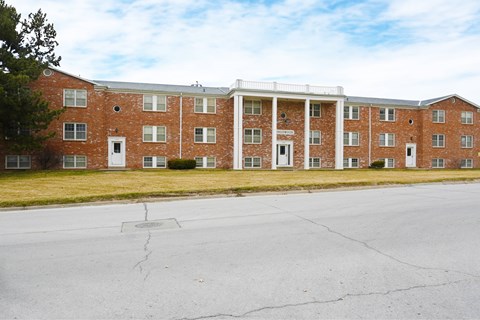 A large red brick building with a white trim around the windows and doors.