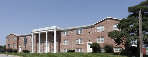 A red brick building with white columns and a white roof.