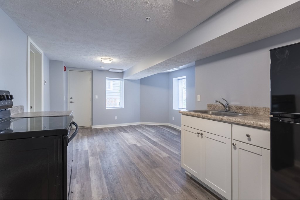 A kitchen with black appliances and white cabinets.