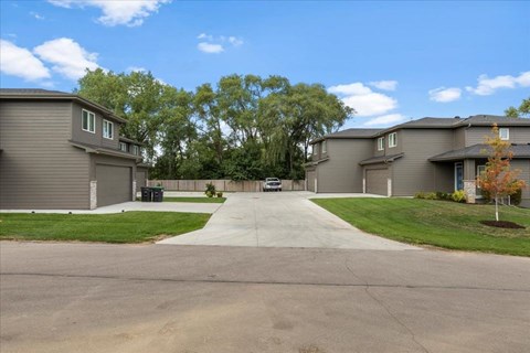 A row of houses with a driveway in the middle.