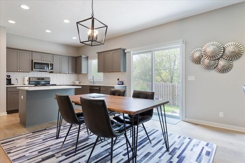 A modern kitchen with a dining table and chairs.