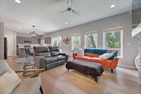 A modern living room with a grey sofa and a brown ottoman.