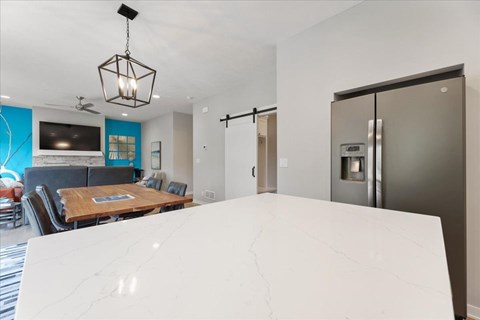 A modern kitchen with a wooden table and a refrigerator.