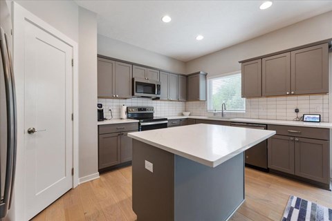 A kitchen with a white island in the middle.