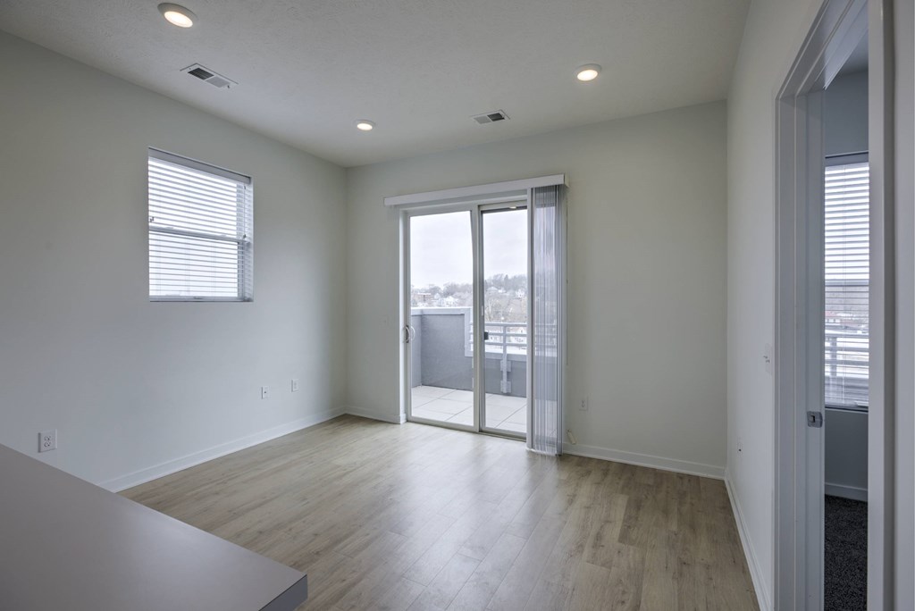 A room with a sliding glass door leading to a balcony.