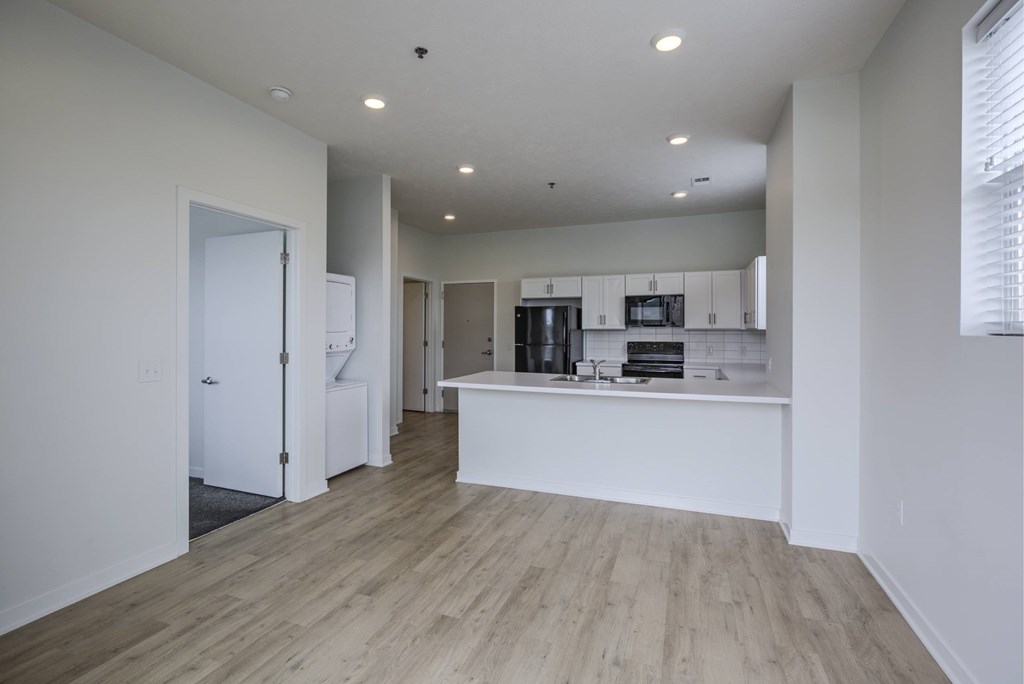 A kitchen with white cabinets and a wooden floor.
