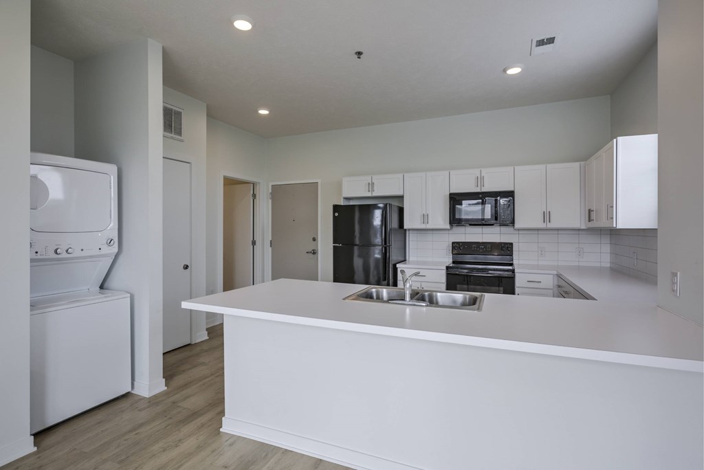 A modern kitchen with white appliances and cabinets.