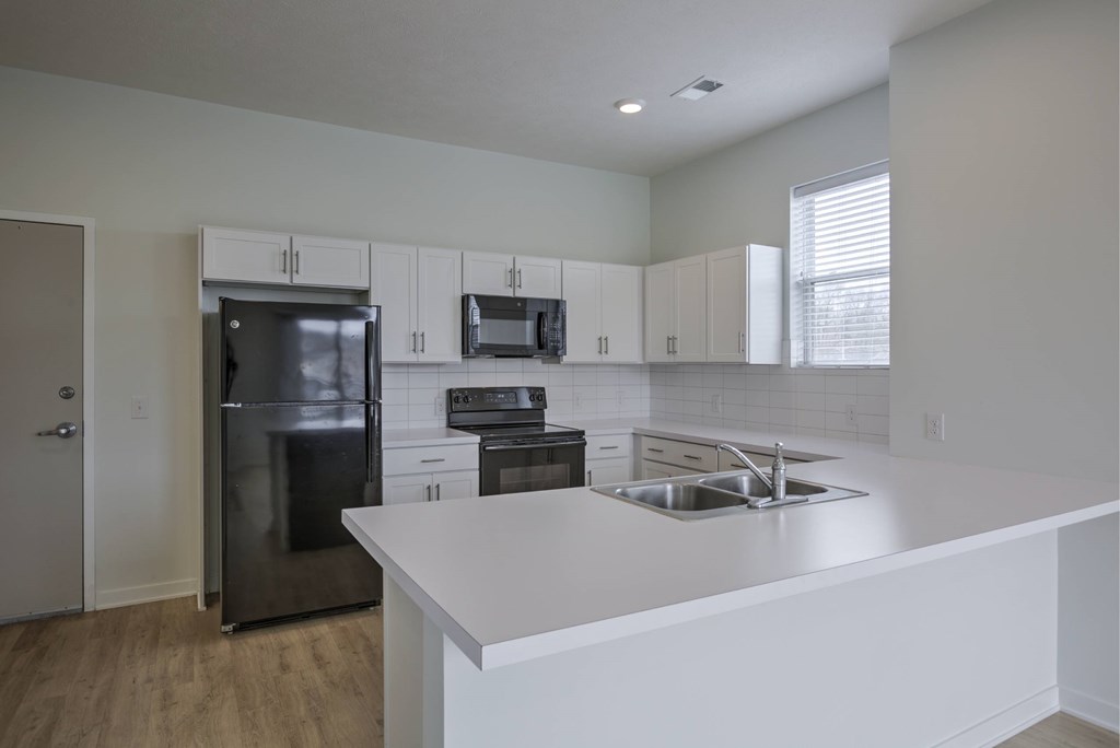 A kitchen with white countertops and stainless steel appliances.