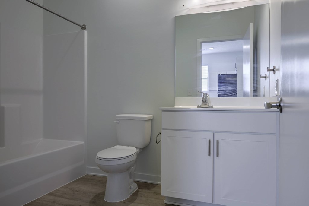 A white toilet sits in a bathroom next to a white sink.