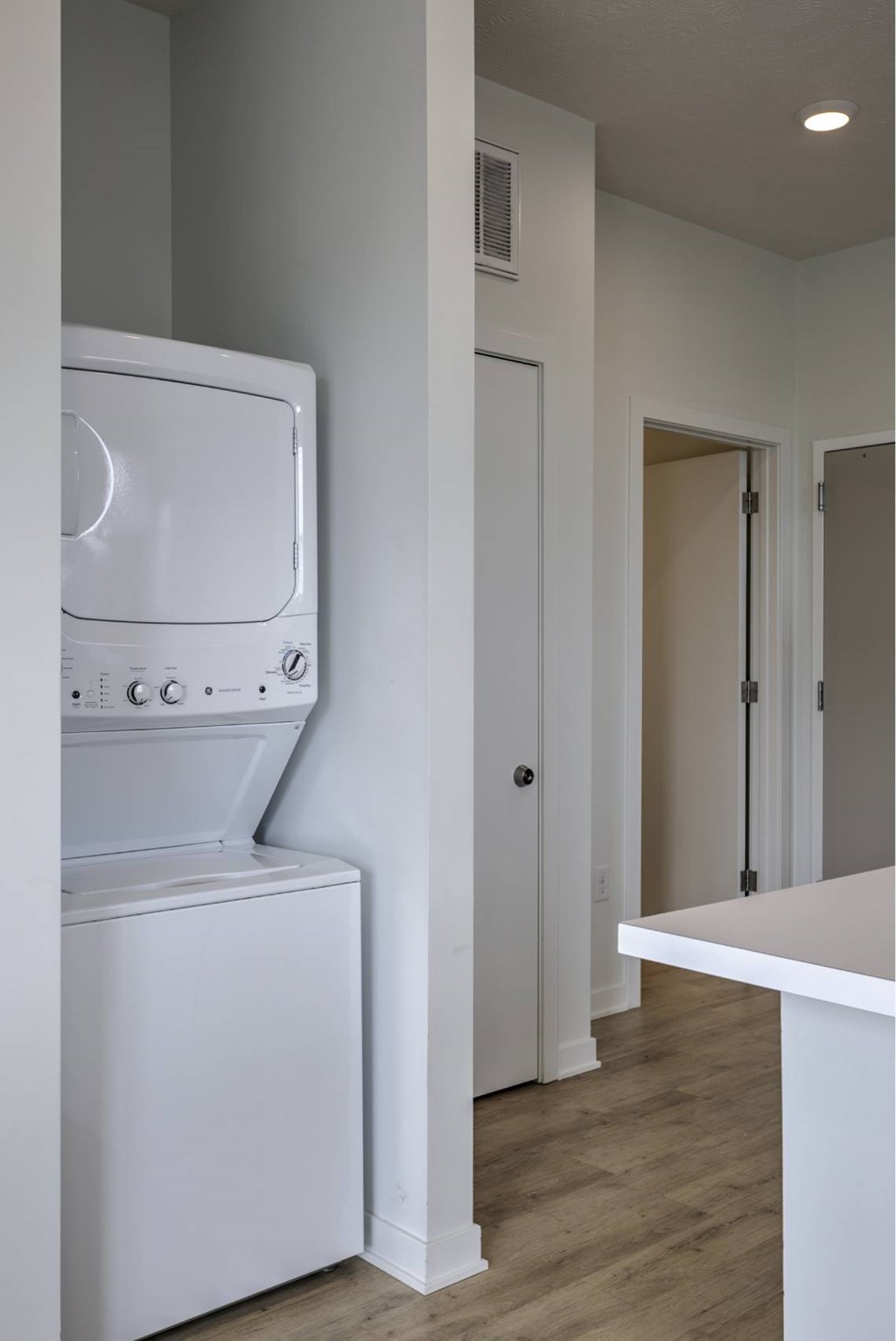 A white washing machine is in a small laundry room.