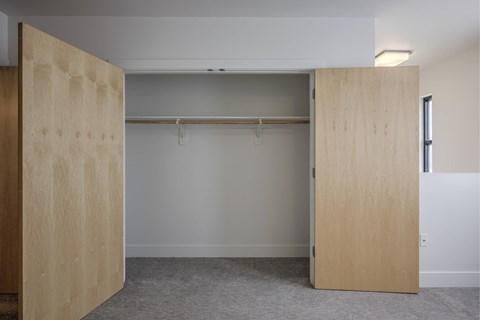 A room with a white wall and a grey carpet.