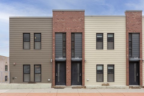 A three-story building with a mix of brick and siding exterior.
