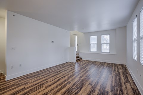 A room with wooden flooring and white walls.