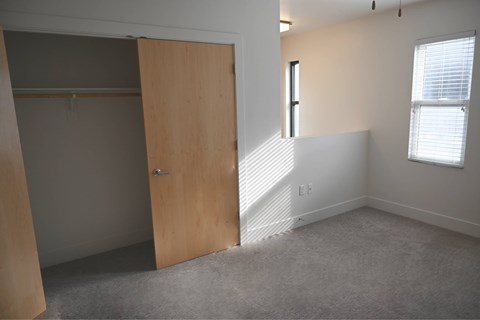 A room with a wooden door and a window with blinds.