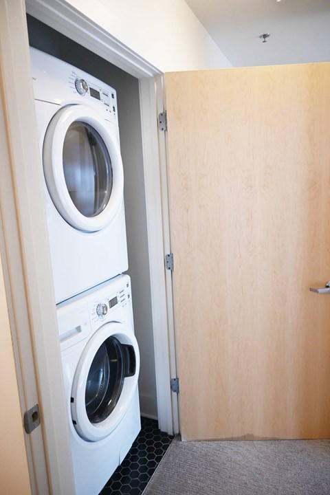 A white washing machine is in a small room.