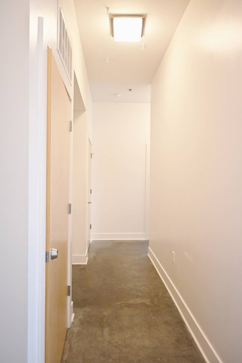 A long hallway with a door on the left.