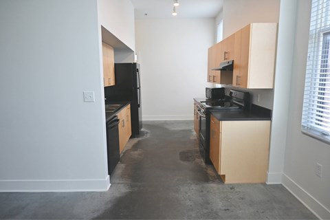 A kitchen with black appliances and wooden cabinets.