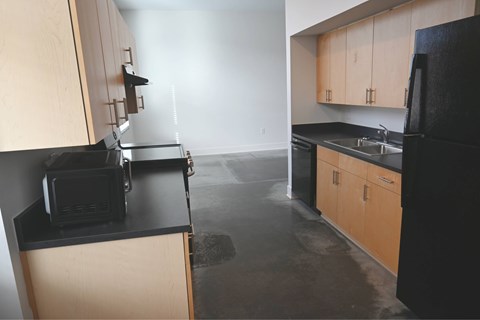 A kitchen with black countertops and wooden cabinets.