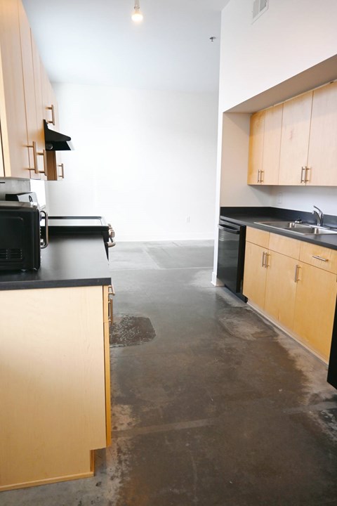 A kitchen with black countertops and wooden cabinets.