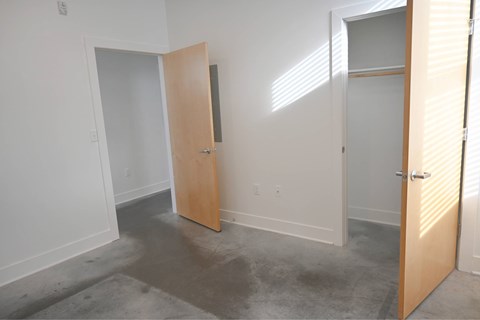 A room with a white wall and a wooden door.