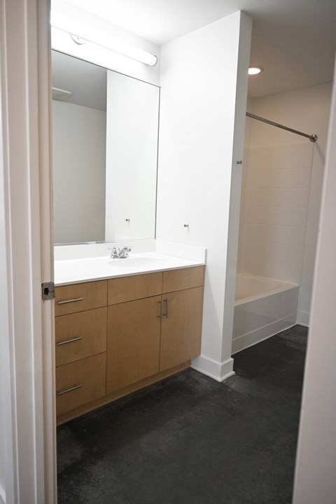 A bathroom with a sink, mirror, and shower.