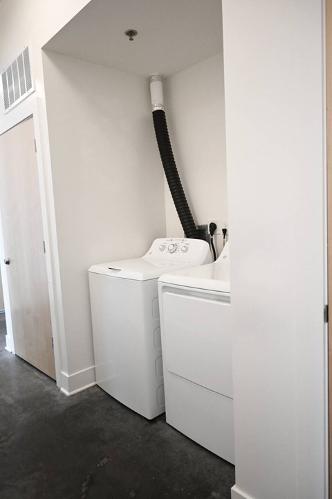 A white washing machine is in a small room.