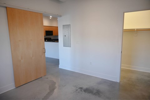 A room with a wooden door and a white wall.