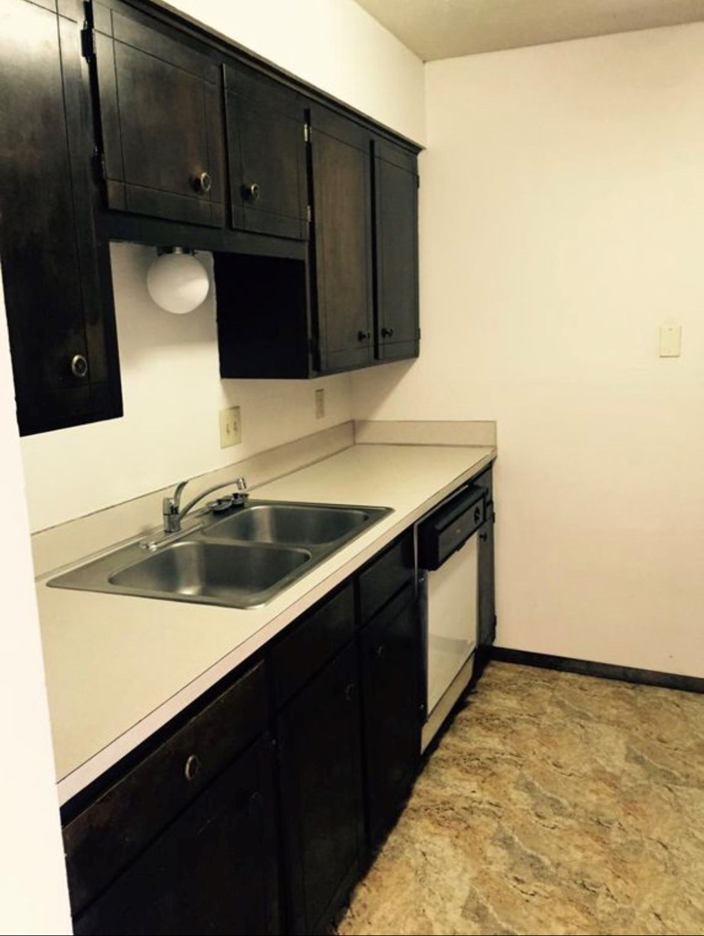A kitchen with black cabinets and a white counter top.