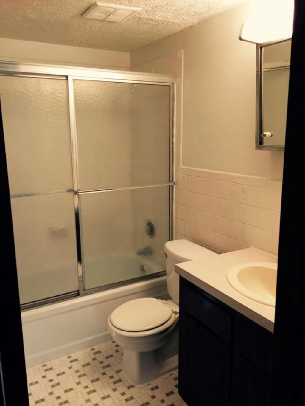 A white toilet sits in a bathroom next to a walk-in shower.