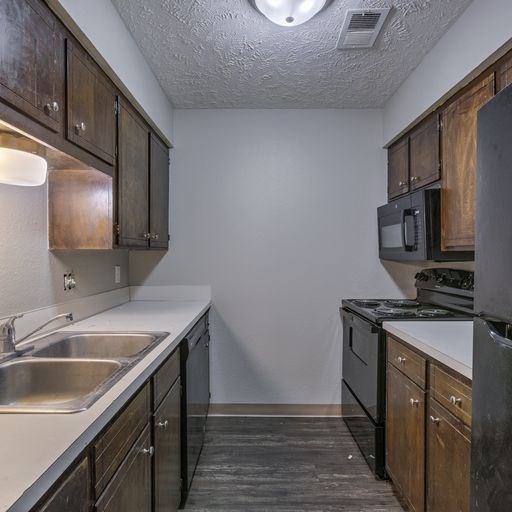 A kitchen with dark wood cabinets and stainless steel appliances.
