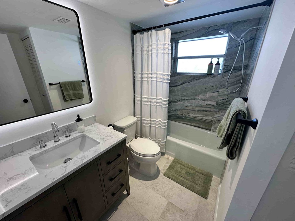 A bathroom with a sink, toilet, and a shower with a glass door.