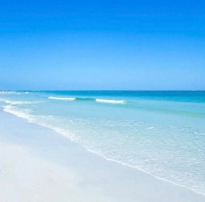 A beautiful beach with clear blue water and white sand.