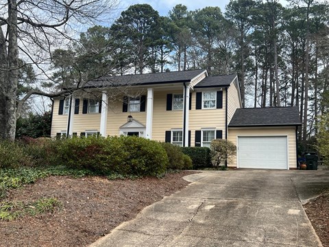 A two-story house with a garage and a driveway.