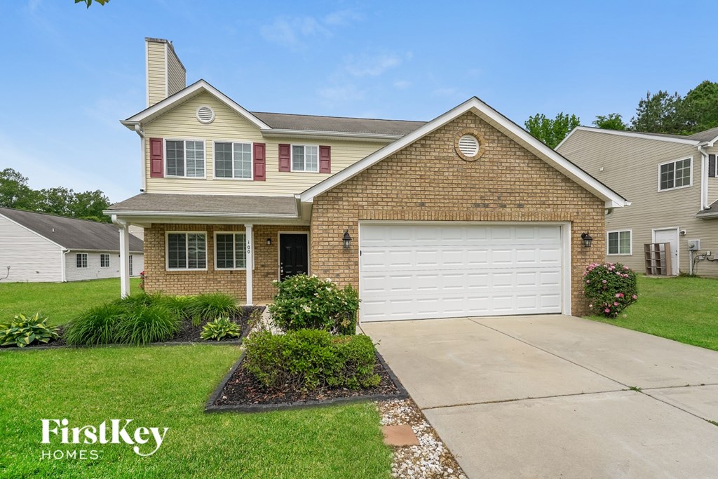 A house with a garage and a driveway in front of it.