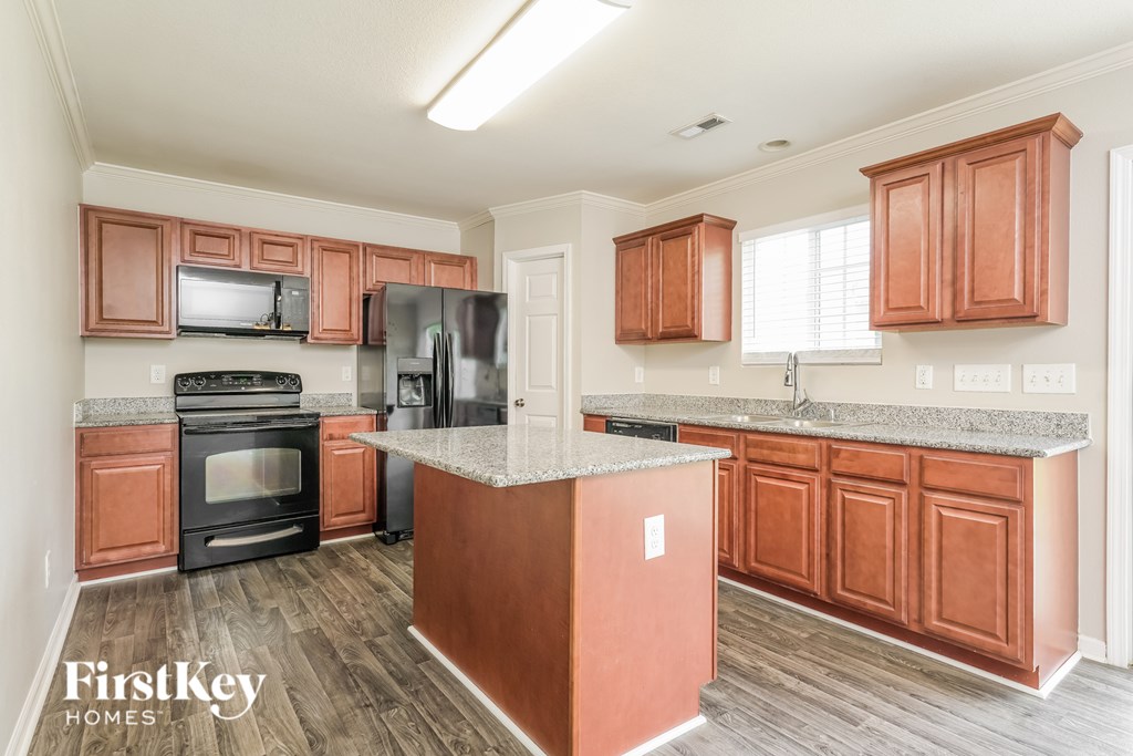 A kitchen with wooden cabinets and a granite countertop.
