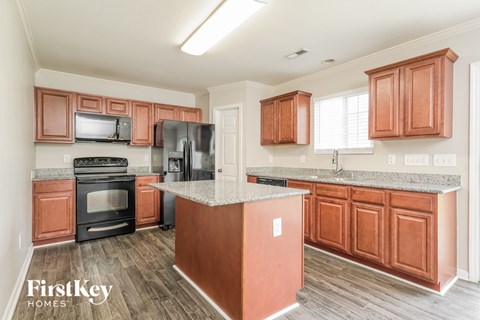 A kitchen with wooden cabinets and a granite countertop.