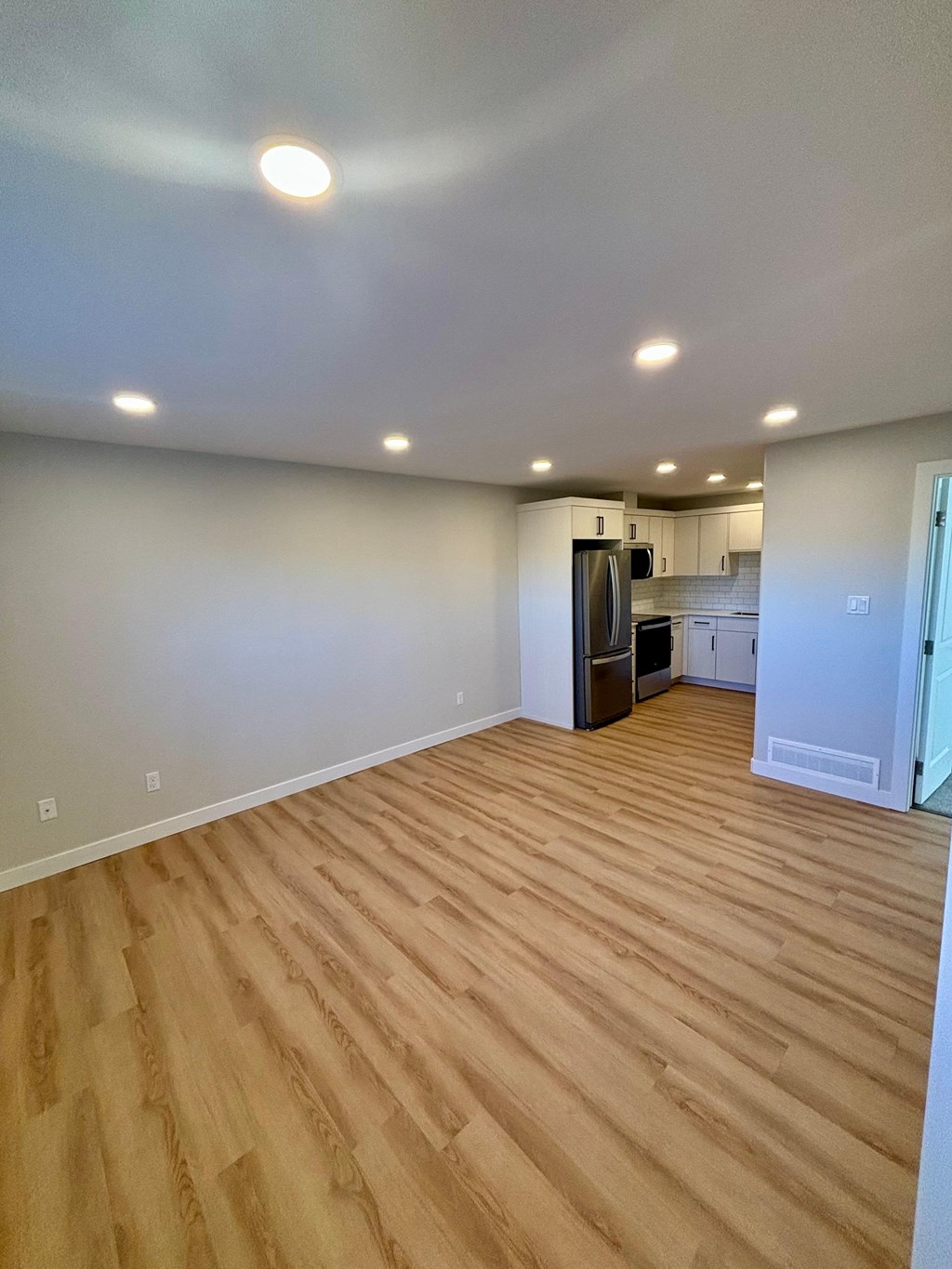 A kitchen area with a refrigerator, microwave, and oven.