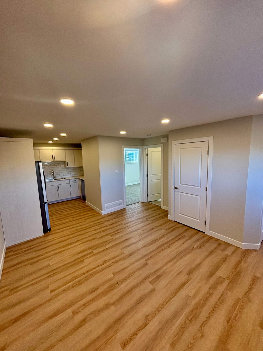 A room with wooden flooring and white walls.
