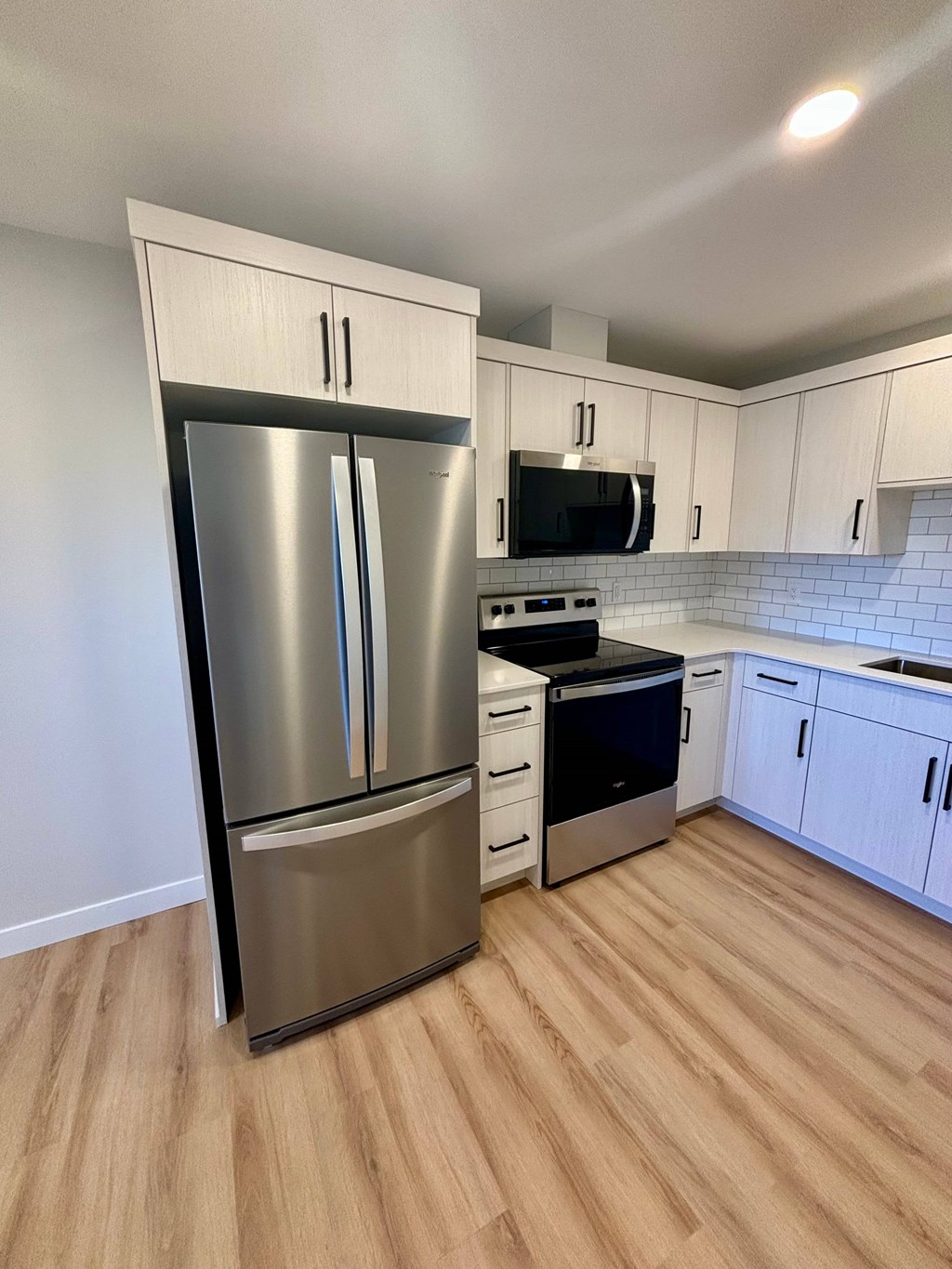 A kitchen with a stainless steel refrigerator and oven.